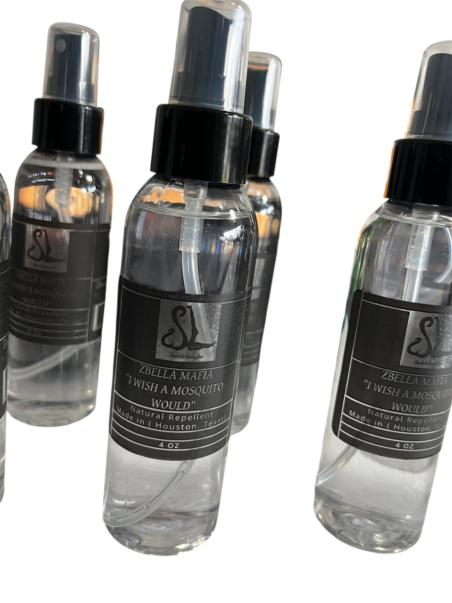 Clear spray bottles with black labels on a white background