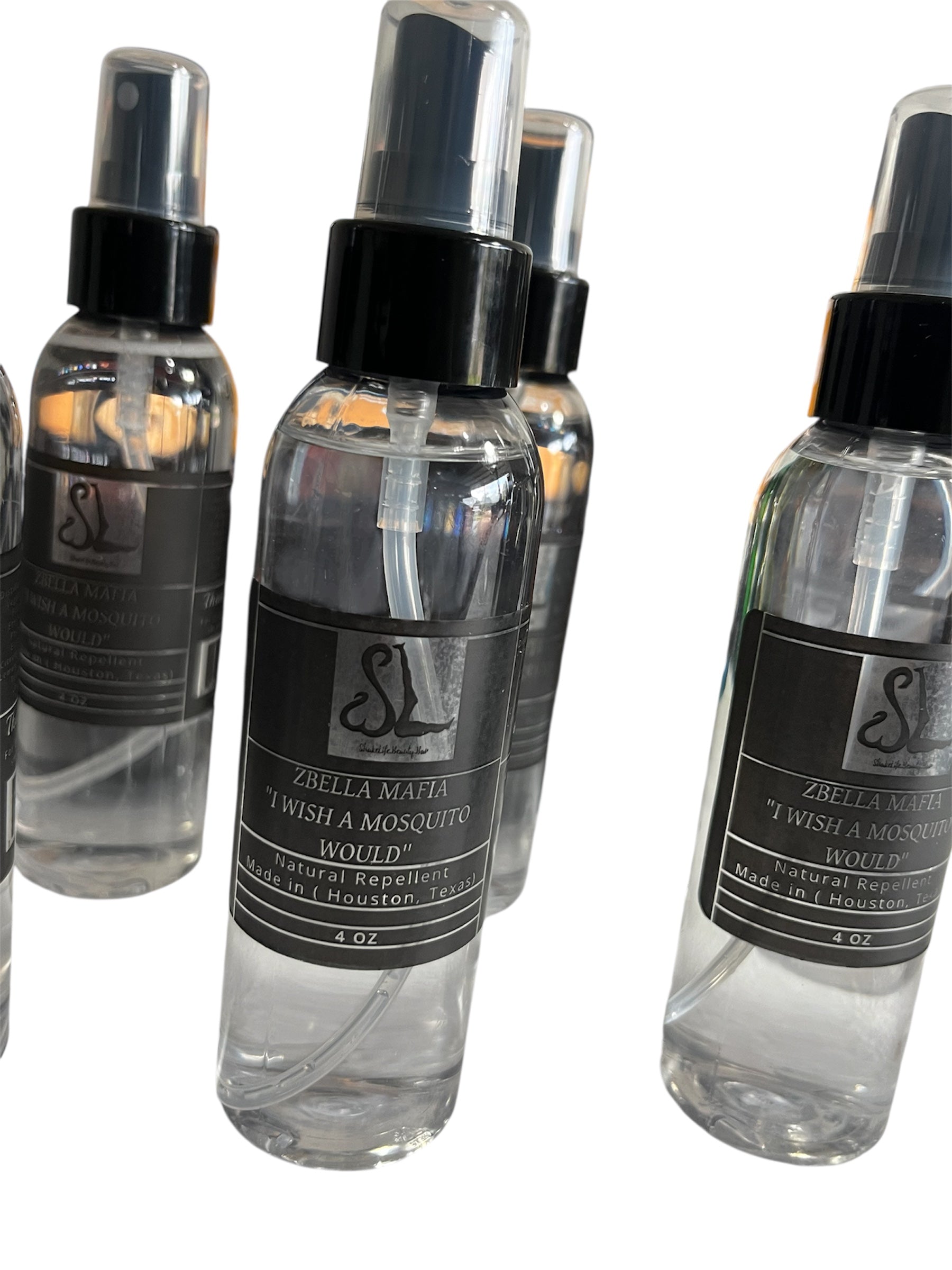 Clear spray bottles with black labels on a white background